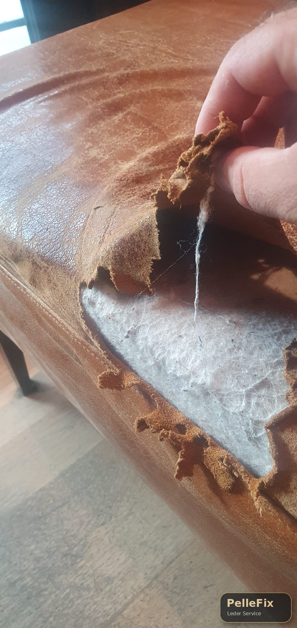 Beschädigtes braunes Ledersofa mit Riss